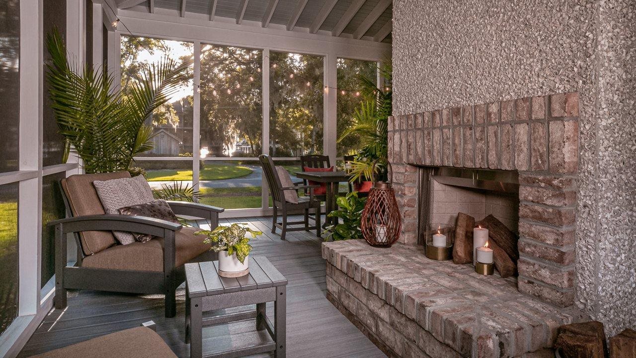 Outdoor screened living area with furniture and fireplace